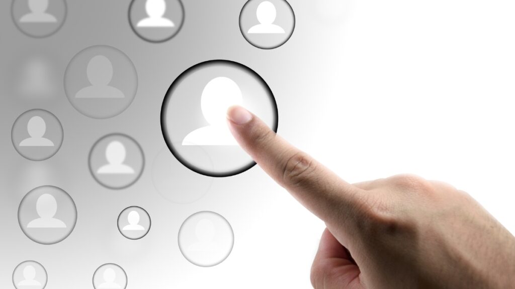 グレーの背景に人のアイコンを指さす人