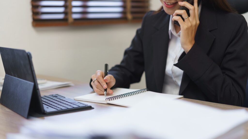 秘書がスマホで電話をしている