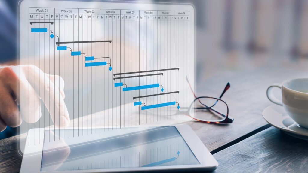ガントチャートで進捗と成果物のマイルストンスケジュールを更新するプロジェクトマネージャー。