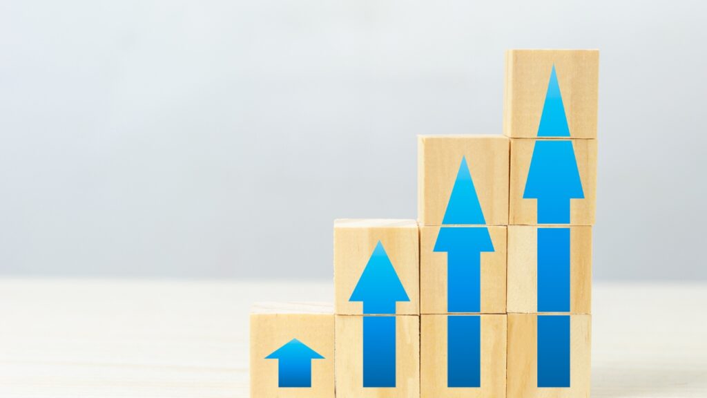 机の上に置かれた木製の立方体のブロックと売上アップのイメージ