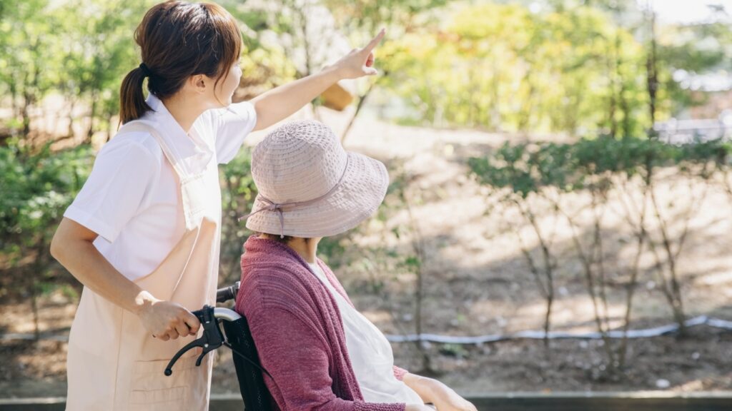 車いすを押す介護従事者