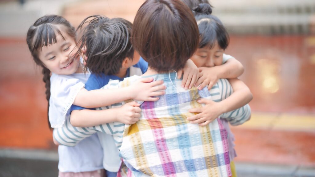 保育園で子供を抱く保育士