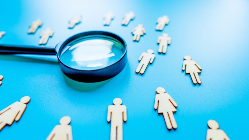 人口動態のイメージ　男女のフィギュアと拡大鏡