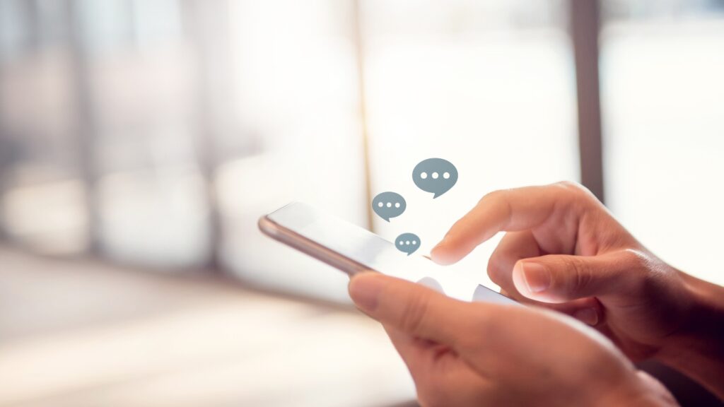 スマホでチャットツールをする人の手