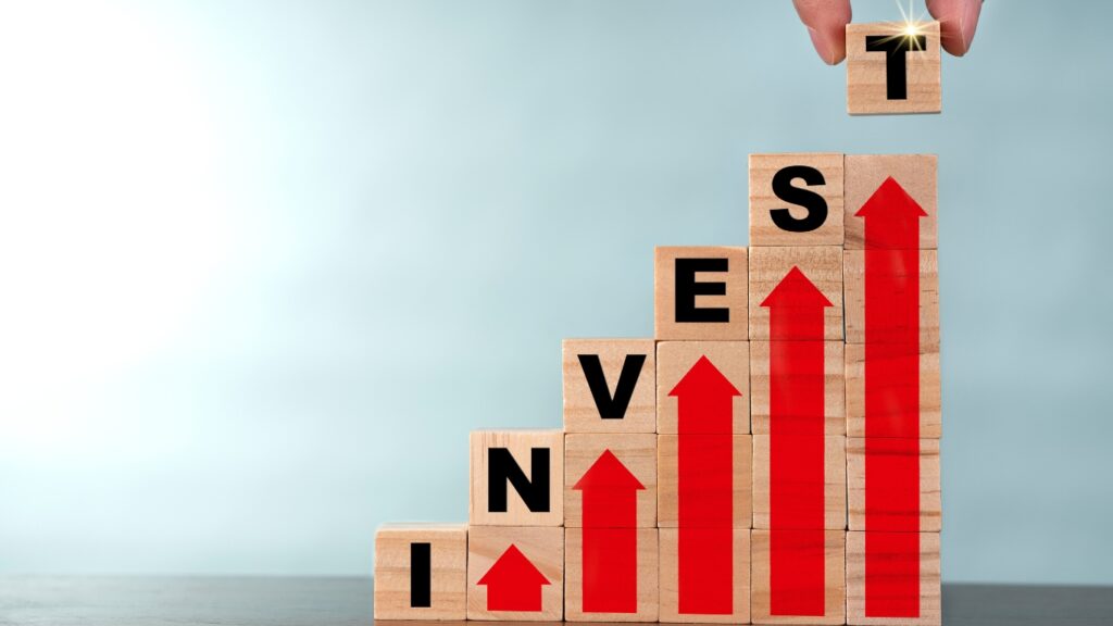 INVESTMENTの文字の期のブロックを積み上げている人