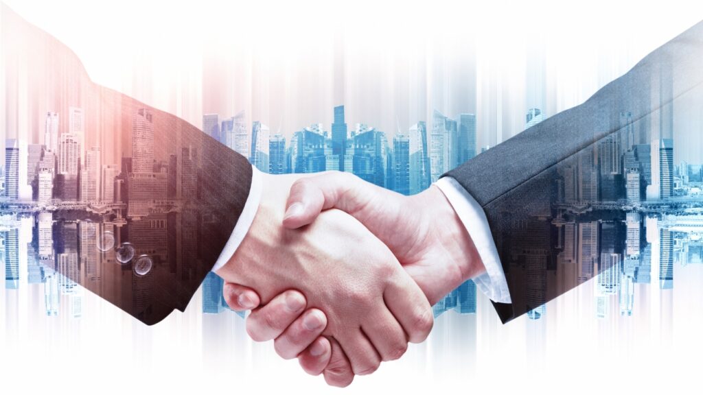 握手するビジネスパーソンと都市のイメージ