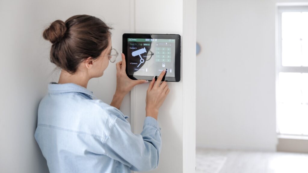 スマートホームセキュリティシステムの操作パネルを使用する女性