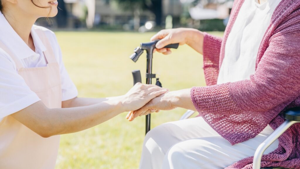 介護士と車いすの高齢女性