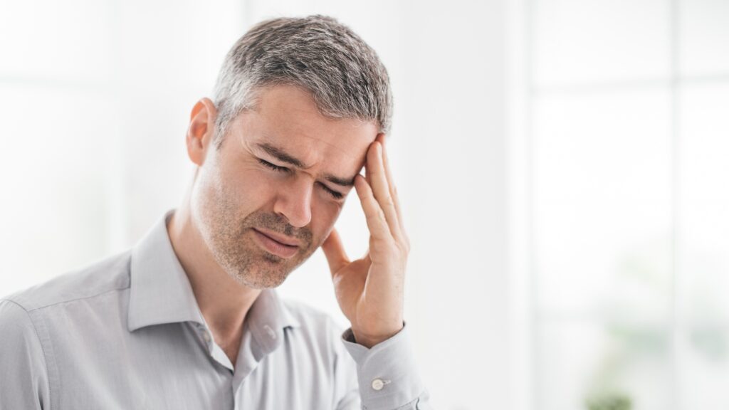 こめかみを抑える男性