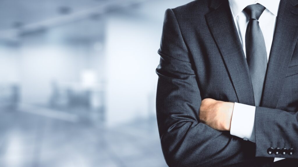 腕を組んでオフィスに立つ男性ビジネスパーソン