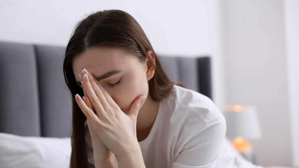 ベッドから起きて疲れている女性